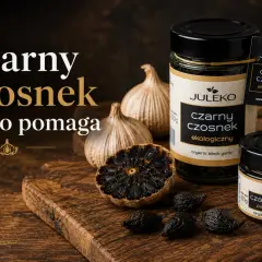 Czarny czosnek w słoikach i na desce, obok świeżych główek. Tajemniczy składnik, który dodaje głębi smaku.