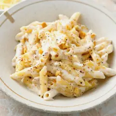 Penne w kremowym sosie z orzechami włoskimi, posypane pieprzem. Pyszne danie, które zachwyci każdego smakosza.