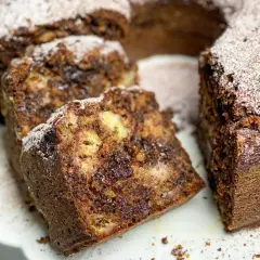 Wilgotne ciasto czekoladowo-bananowe, posypane cukrem pudrem, idealne jako ciasto do kawy.