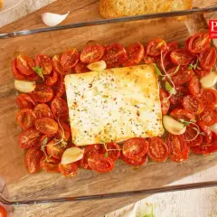Pyszna feta zapiekana z pomidorkami koktajlowymi, czosnkiem i ziołami. Idealna na przystawkę lub lekki posiłek.