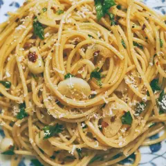 Pyszny makaron aglio olio z czosnkiem, natką pietruszki i płatkami chili, posypany parmezanem.