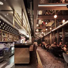 Elegancki bar i wygodne fotele tworzą klimatyczne restauracje Katowice. Goście relaksują się przy widoku na nocne miasto.