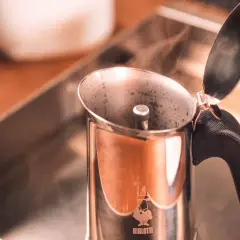 Para dowodzi, jak zrobić kawę w kawiarce. Kawiarka Bialetti parzy aromatyczny napój.