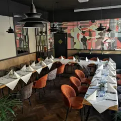 Elegancka sala bankietowa z nakrytymi stołami, idealna na wyjątkowe okazje. To miejsce to prawdopodobnie najlepsza restauracja w Olsztynie.