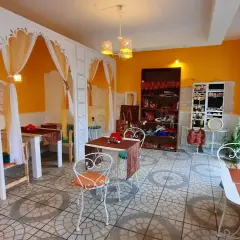 Wnętrze restauracji Samsara w Opolu, z żółtymi ścianami, białymi zdobieniami i stolikami. Idealne miejsce, by zapoznać się z ich menu.