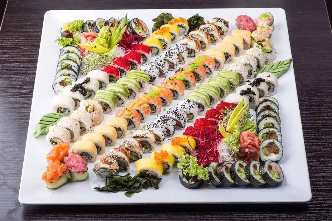Ogromna taca sushi z różnymi rolkami, idealna do wyboru z menu Mizumi Sushi. Kolorowe składniki i estetyczne ułożenie.