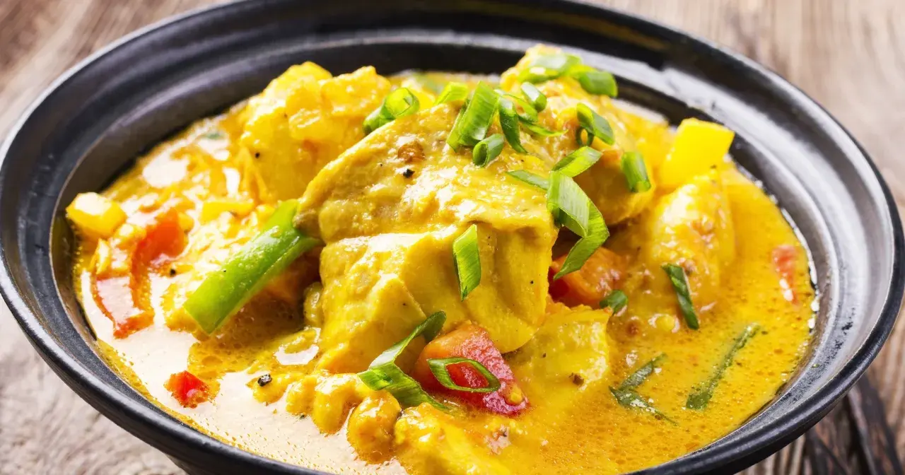 Aksamitne curry bez mięsa z kawałkami tofu, papryką i zieloną cebulką w aromatycznym, żółtym sosie.