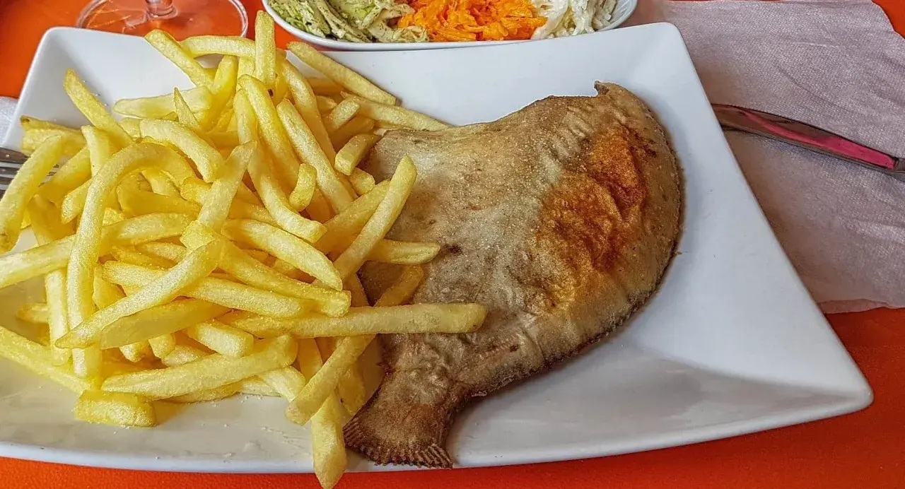 Złocista flądra z piekarnika, podana z chrupiącymi frytkami i surówką. Pyszny obiad gotowy!
