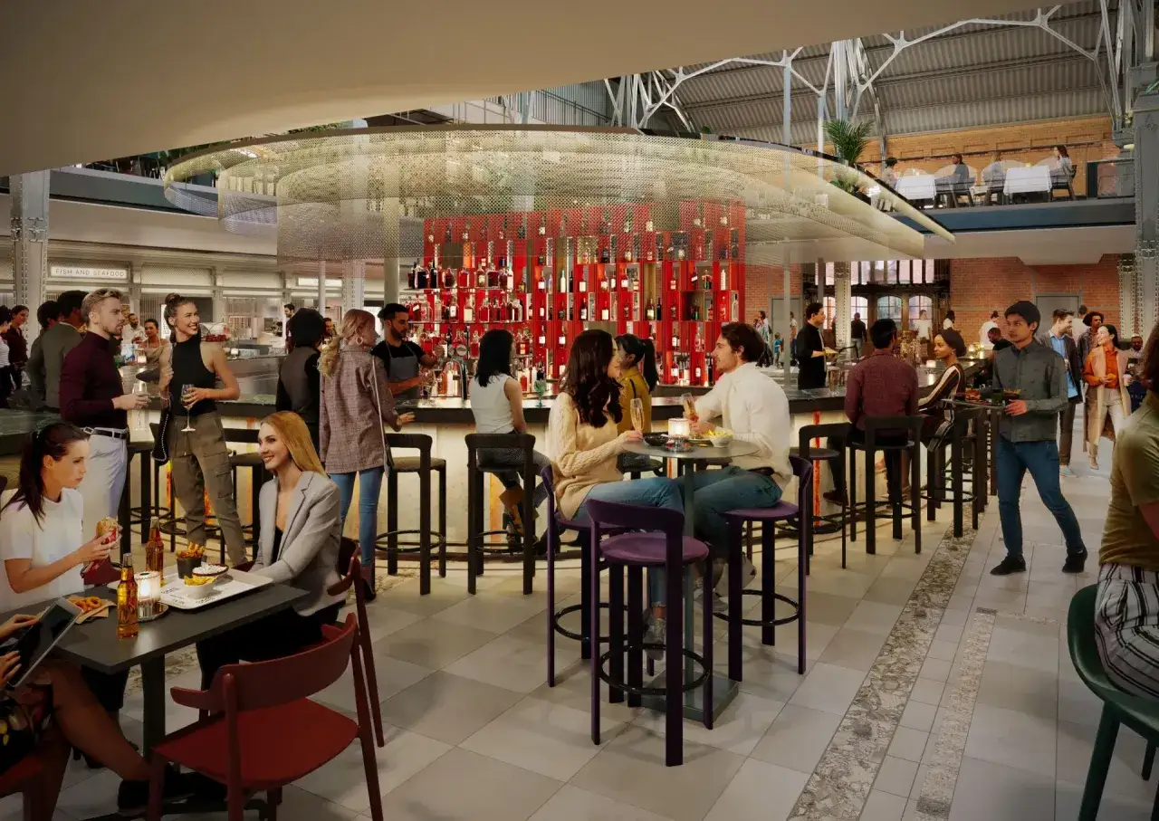Nowe restauracje w Gdańsku tętnią życiem. Ludzie siedzą przy barze i stolikach, ciesząc się posiłkami i napojami w nowoczesnym wnętrzu.