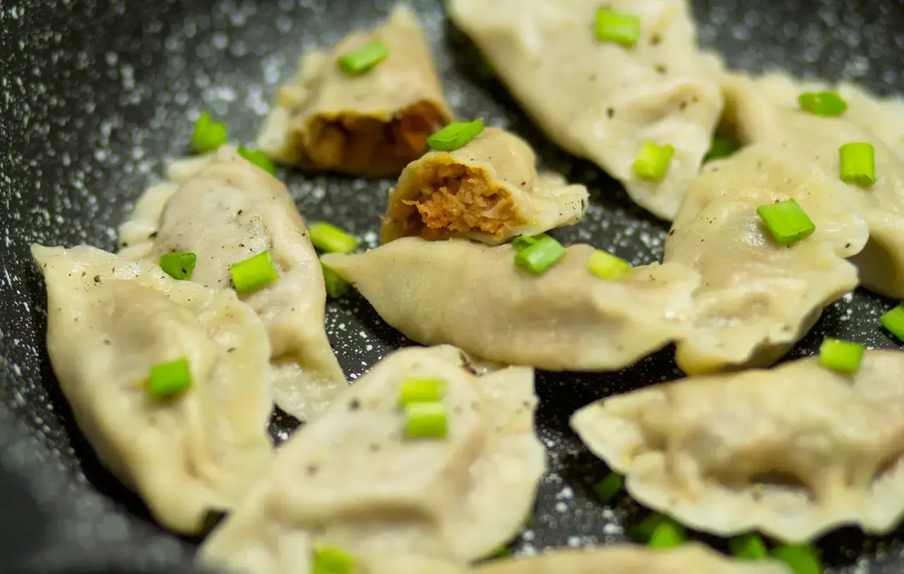Pyszne pierogi z soczewicą, posypane szczypiorkiem, gotowe do podania.