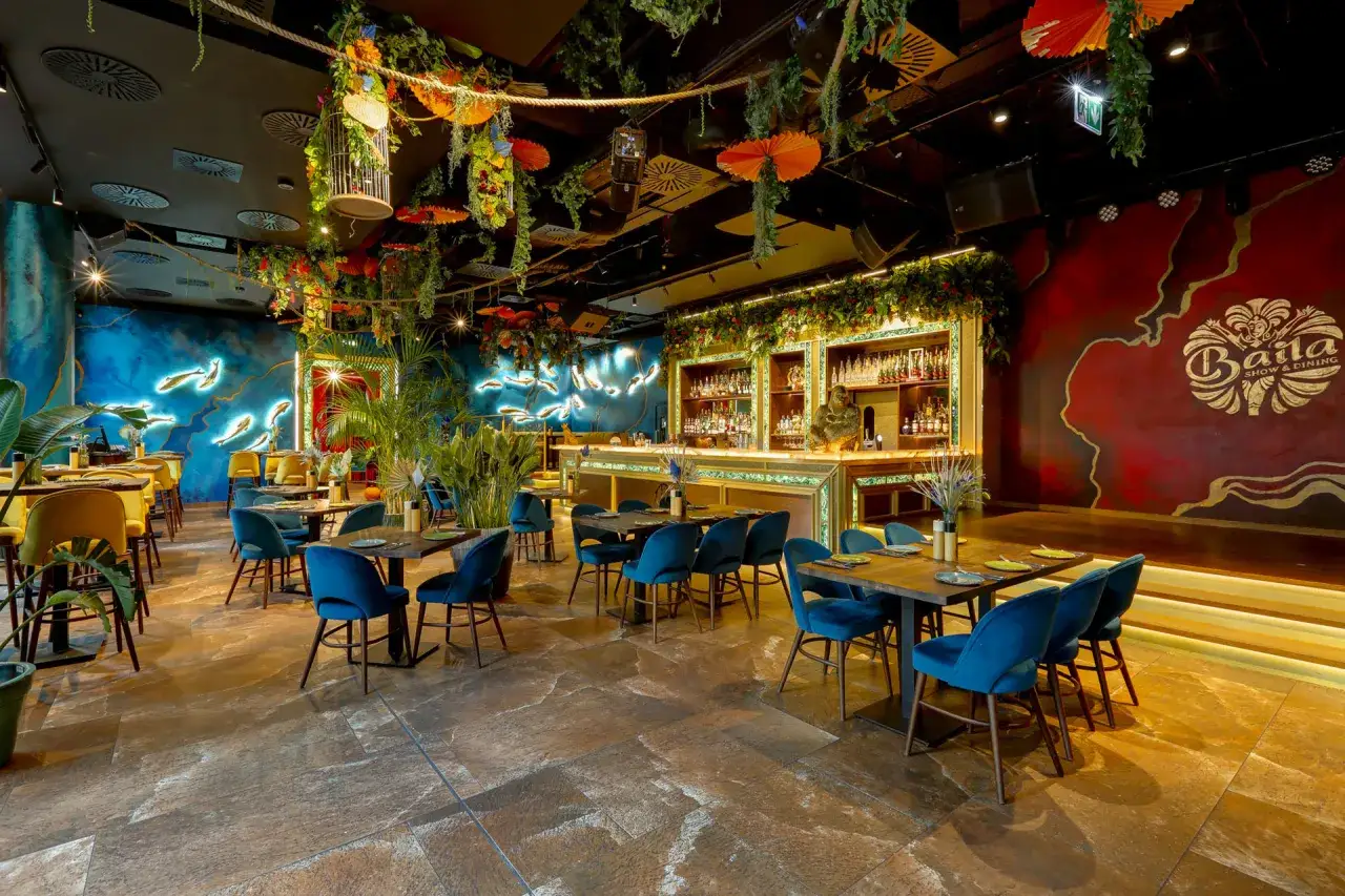 Egzotyczny wystrój restauracji z neonowymi rybami i bujną roślinnością. Idealne miejsce na wieczór, które może znaleźć się w rankingu top 10 restauracji Warszawa.