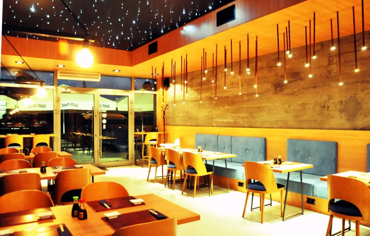 Nowoczesne wnętrze restauracji z gwiazdkowym sufitem i drewnianymi elementami. Idealne miejsce na najlepsze sushi w Gdańsku.