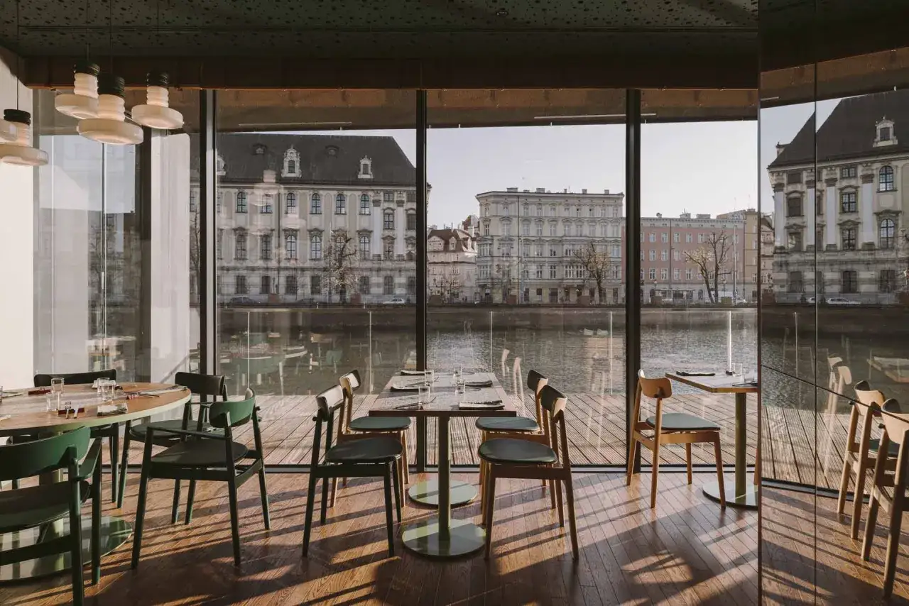 Nowoczesne wnętrze z widokiem na Odrę i zabytkową architekturę. Idealne miejsce na romantyczną kolację w jednej z klimatycznych restauracji Wrocławia.