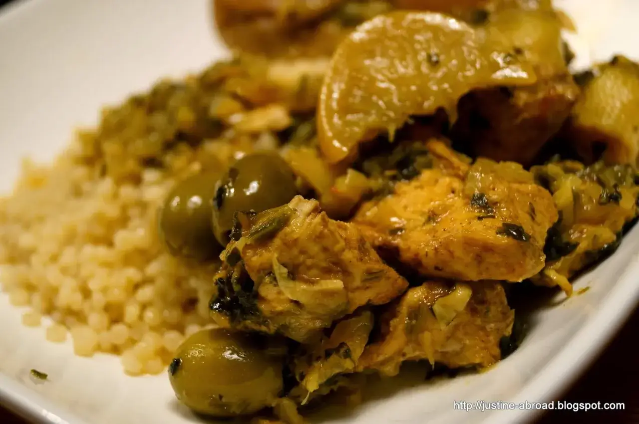 Aromatyczny tagine z kurczakiem, podany z kuskusem i zielonymi oliwkami. Danie wygląda apetycznie i zachęca do spróbowania.