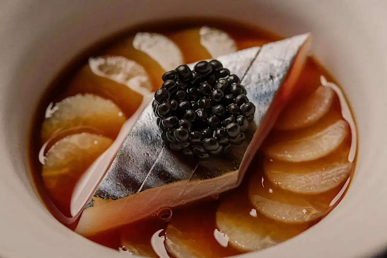 Wykwintne danie z ryby i kawioru, godne restauracji z gwiazdką Michelin w Polsce. Delikatne plastry warzyw w aromatycznym sosie.